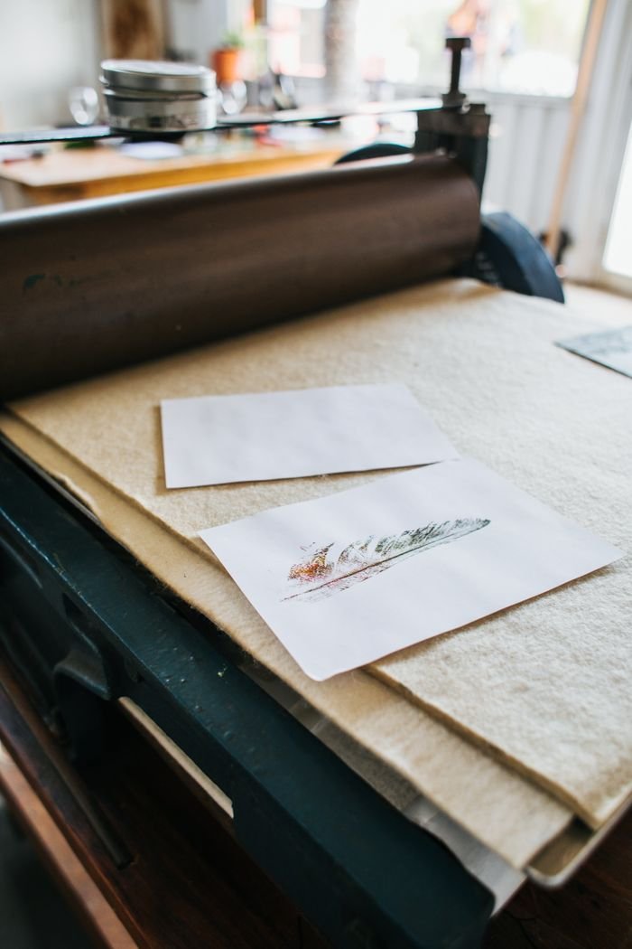 Metal printing press with creative drawing on paper placed in light modern studio with special professional equipment on blurred background